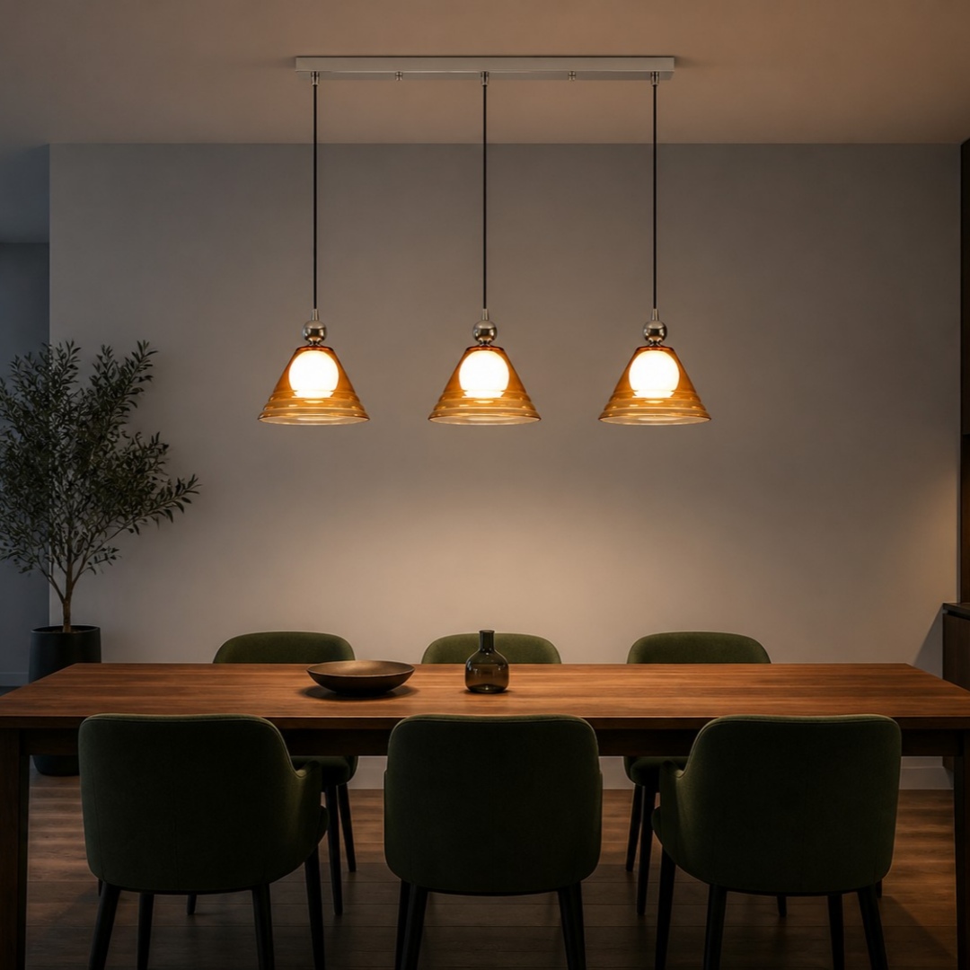 Lámpara colgante de cristal ámbar de tres luces sobre una mesa de comedor larga.