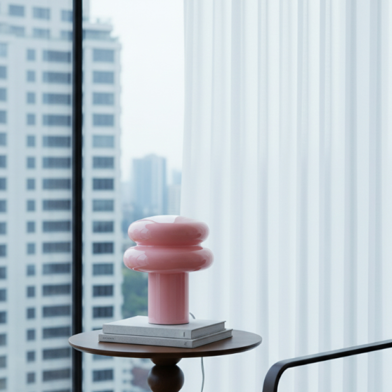 Orra Opalglas-Tischleuchte in Rosa am Fenster