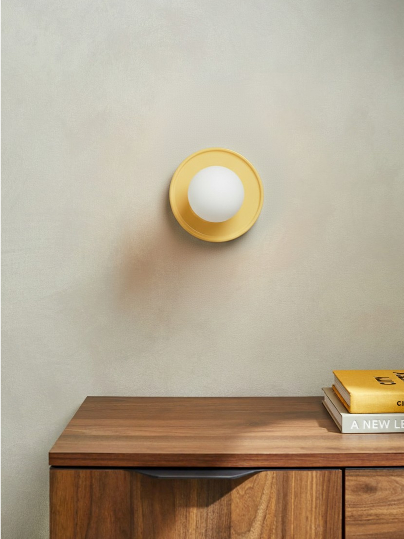 Customer photo of yellow round wall lamp above wood cabinet
