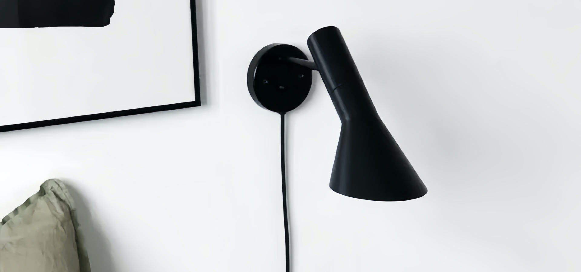 AJ Wandleuchte in Schwarz an der Wand